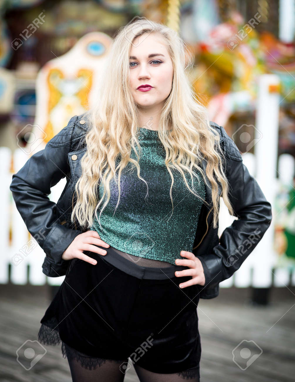 Portrait Of A Confident Blond Teenager With Long Hair Wearing A Leather Jacket Green Glittery Portrait Of A Confident Blond Teenager With Long Hair Wearing A Leather Jacket Green Glittery