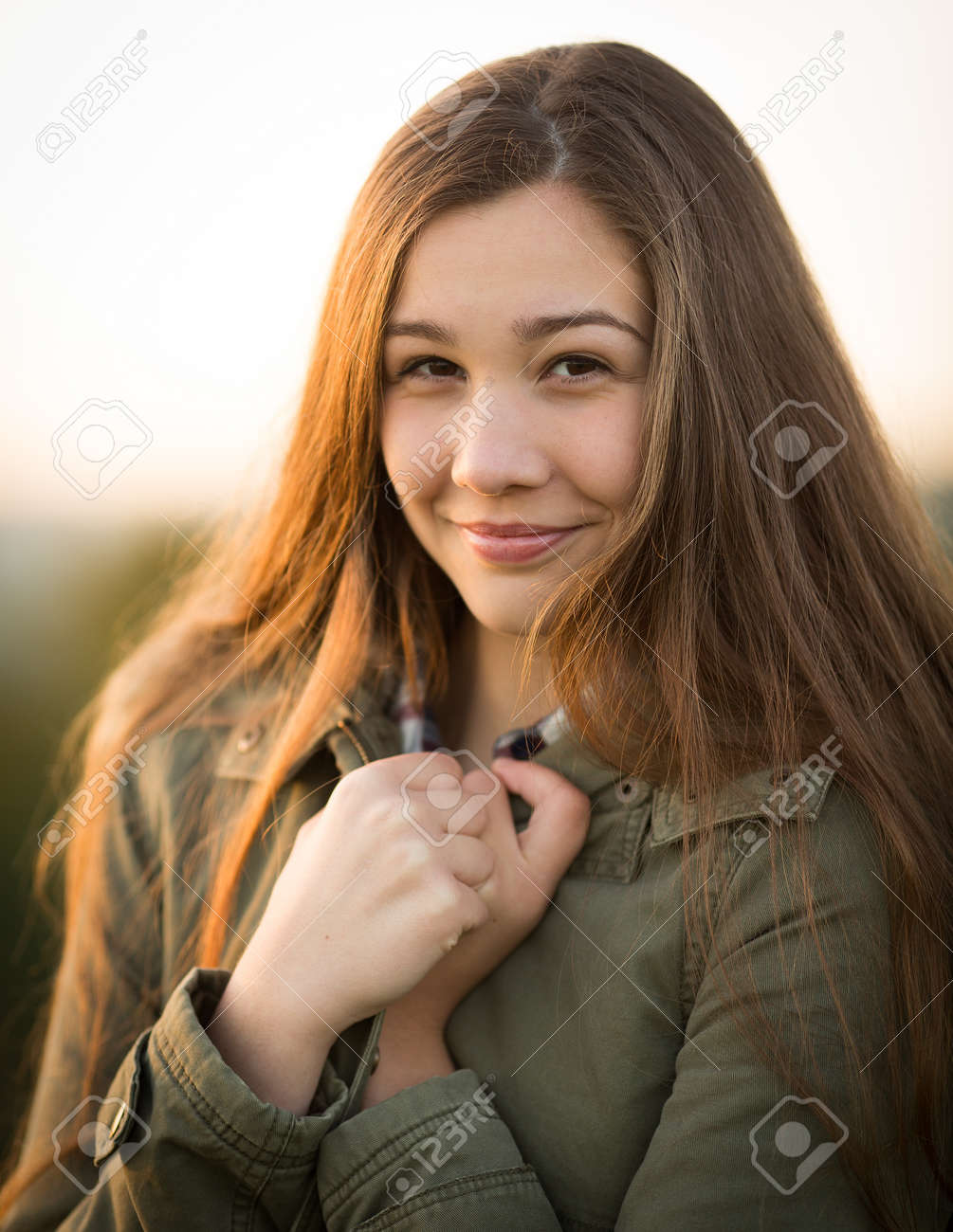 Portrait Of A Beautiful Teen Girl With Long Hair Wearing A Thick Winter Coat Holding It Portrait Of A Beautiful Teen Girl With Long Hair Wearing A Thick Winter Coat Holding It