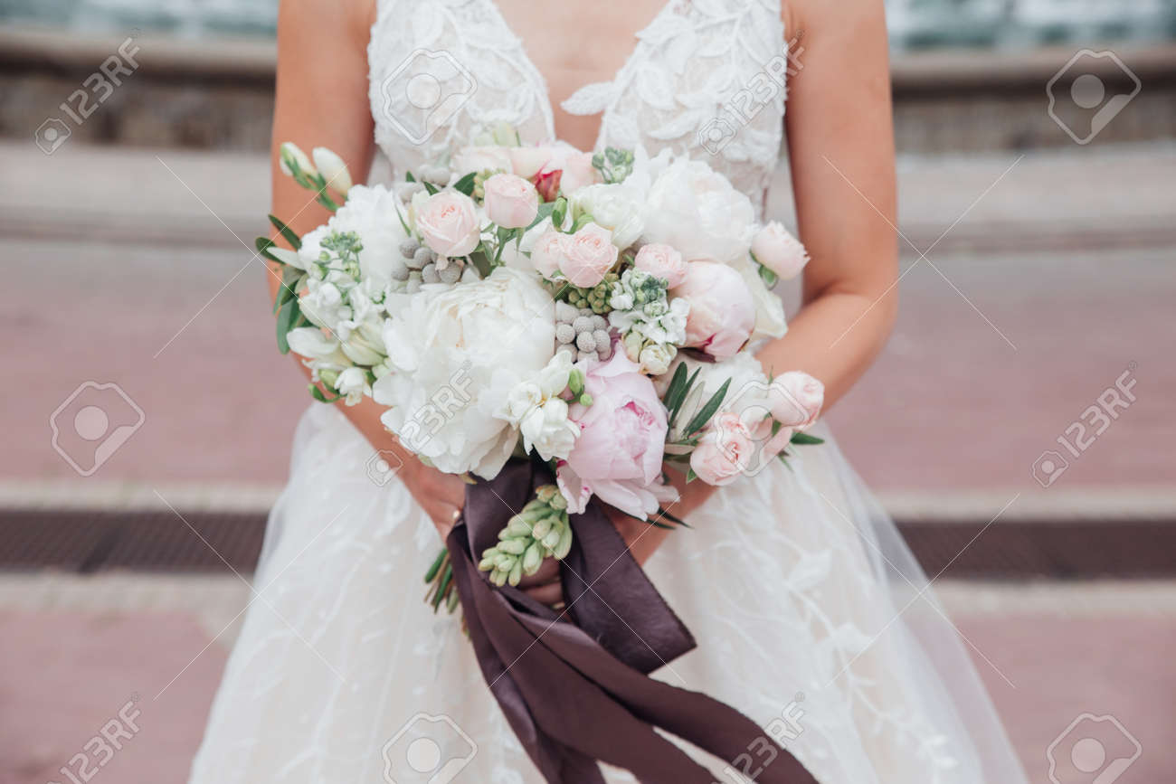 wedding bouquet in brides hands outdoor in wedding day - 142801188 wedding bouquet in brides hands outdoor in wedding day - 142801188