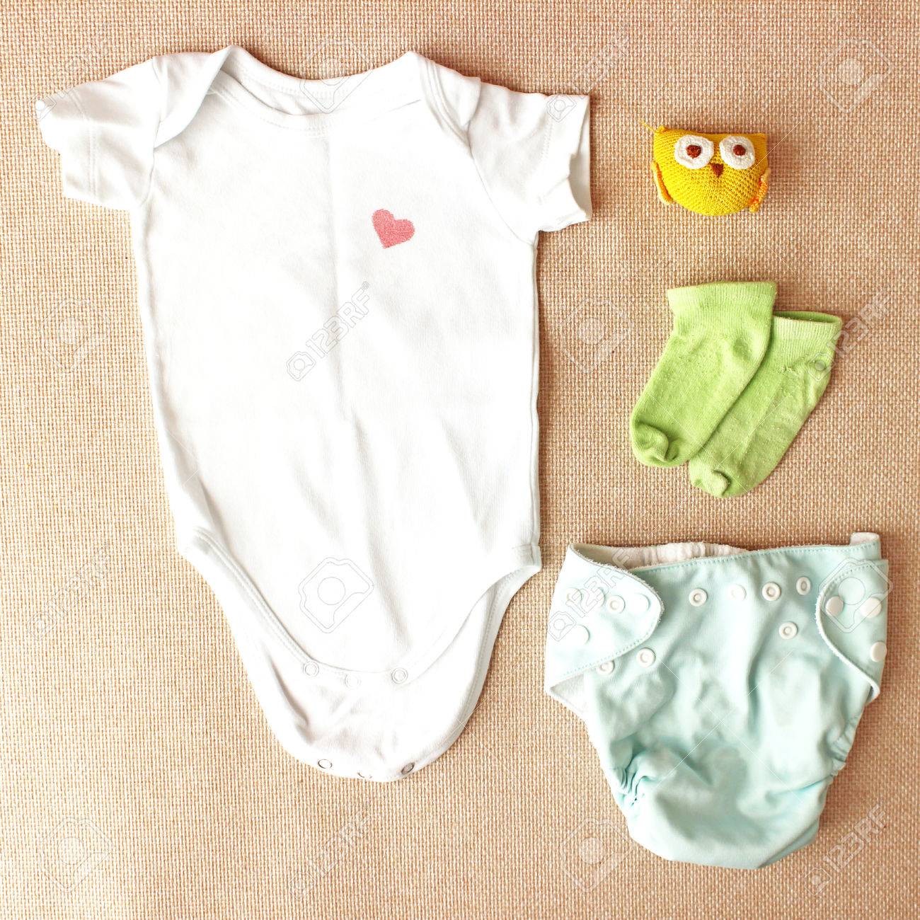 newborn clothes flat lay with white body and toy baby fashion baby fashion blog