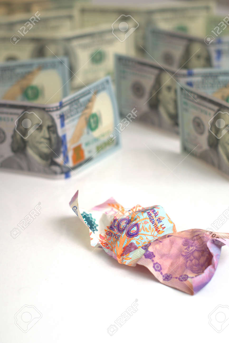アルゼンチン経済危機と通貨切り下げ。くしゃくしゃのアルゼンチンの紙幣と無傷の米国の紙幣。コンセプトのメタファー。の写真素材・画像素材 Image  130790256