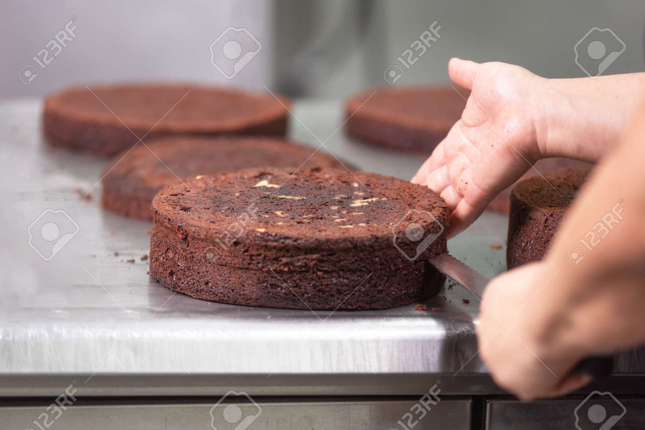 Professional confectioner making a delicious cake in the pastry shop. - 117557183 Professional confectioner making a delicious cake in the pastry shop. - 117557183