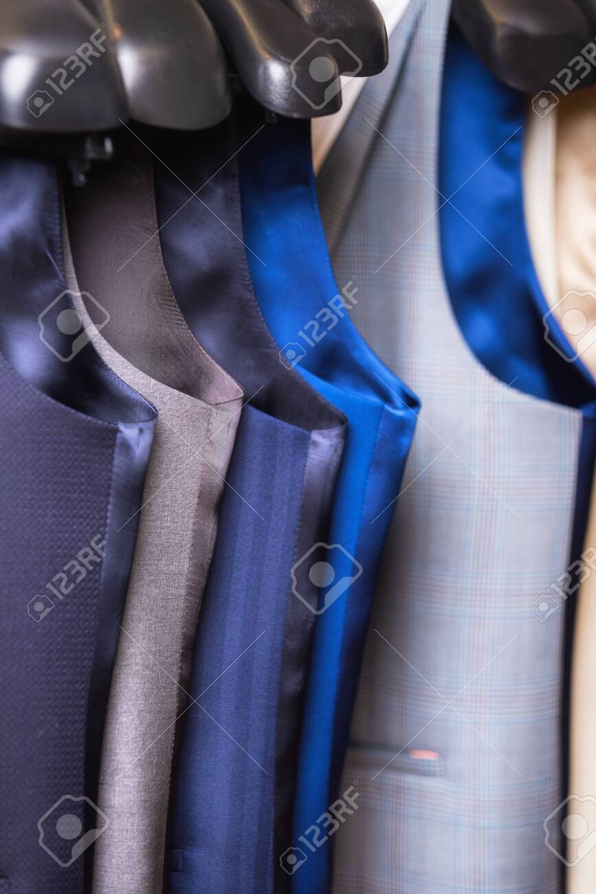 Stylish mens vest close up. Male svest hanging in a row. Mens Clothing, shopping in boutiques. vest and suits in a male luxury store. - 124787972 Stylish mens vest close up. Male svest hanging in a row. Mens Clothing, shopping in boutiques. vest and suits in a male luxury store. - 124787972