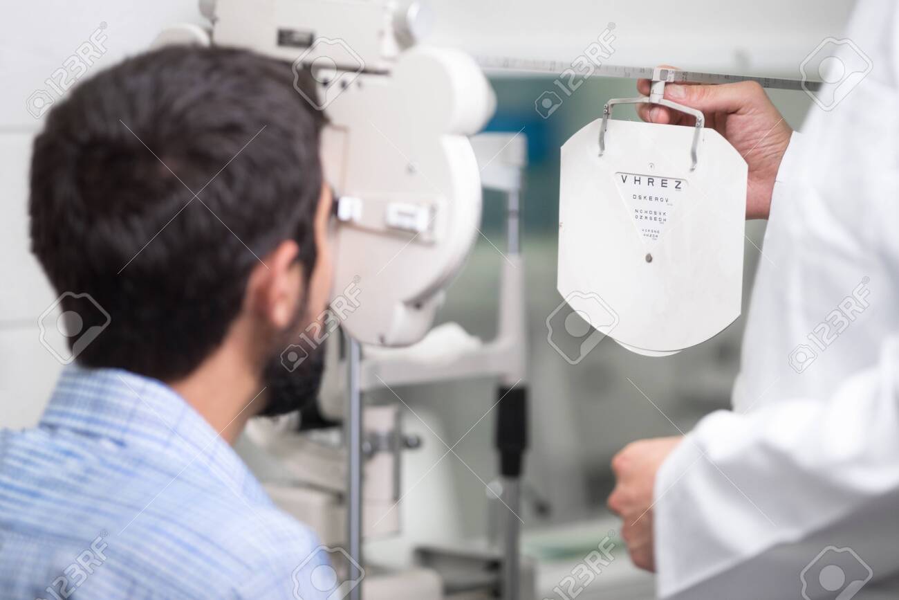 male doctor ophthalmologist is checking the eye vision of handsome young man in modern clinic. Doctor and patient in ophthalmology clinic. - 127134409 male doctor ophthalmologist is checking the eye vision of handsome young man in modern clinic. Doctor and patient in ophthalmology clinic. - 127134409