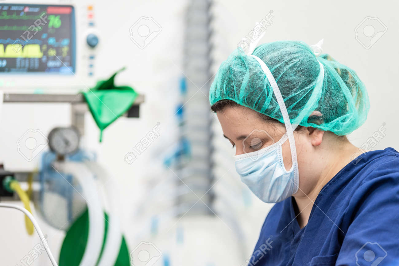 Covid-19 outbreak. Healthcare worker. Nurse working in intensive care unit. Mechanical ventilation system in the background. - 143131893 Covid-19 outbreak. Healthcare worker. Nurse working in intensive care unit. Mechanical ventilation system in the background. - 143131893