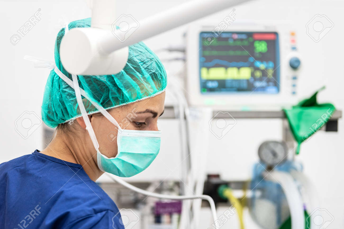 Covid-19 outbreak. Healthcare worker. Nurse working in intensive care unit. Mechanical ventilation system in the background. - 143132180 Covid-19 outbreak. Healthcare worker. Nurse working in intensive care unit. Mechanical ventilation system in the background. - 143132180