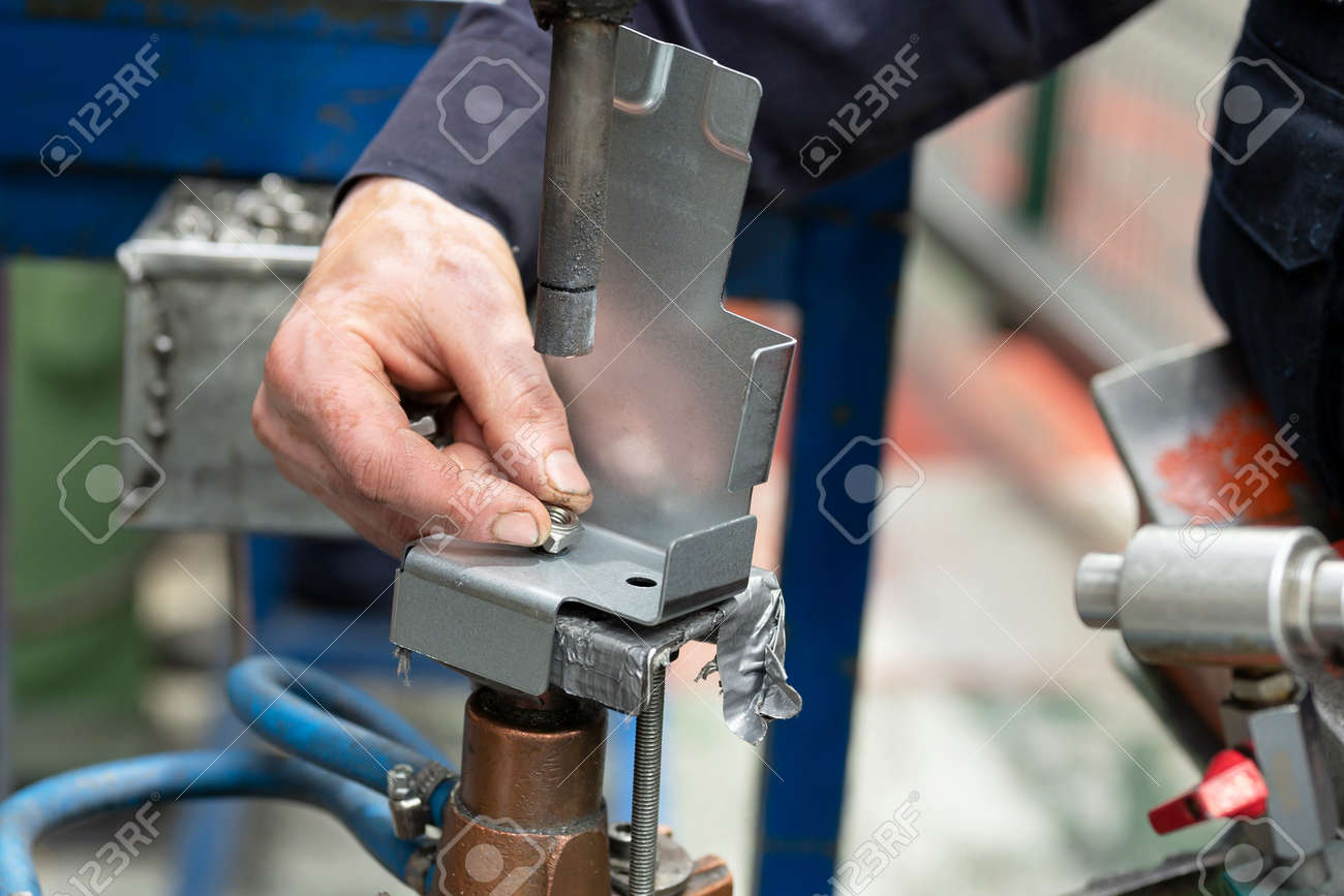 Close up of a metal element being spot-welded by a factory worker. Industry concept. - 169702176 Close up of a metal element being spot-welded by a factory worker. Industry concept. - 169702176
