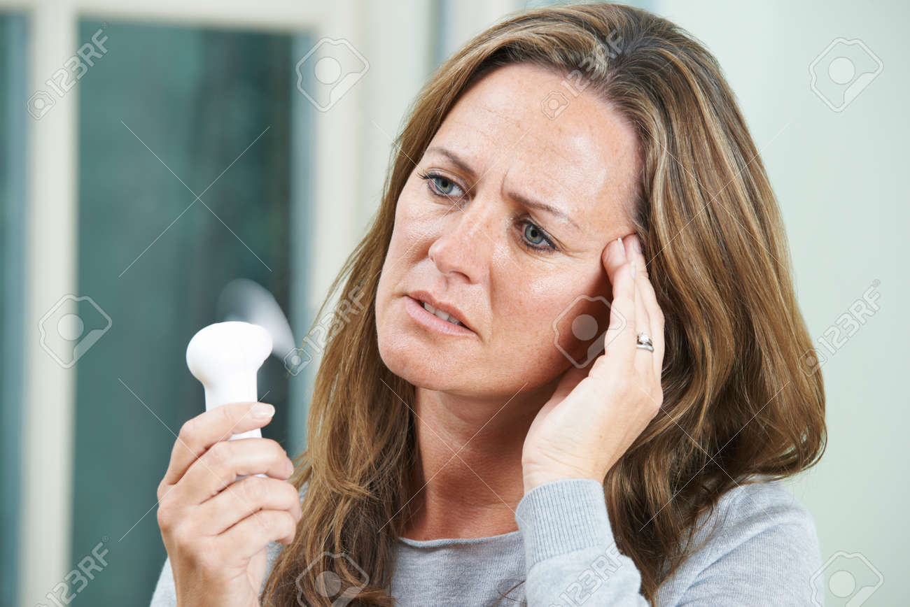 Mature Woman Experiencing Hot Flush From Menopause - 54861242 Mature Woman Experiencing Hot Flush From Menopause - 54861242