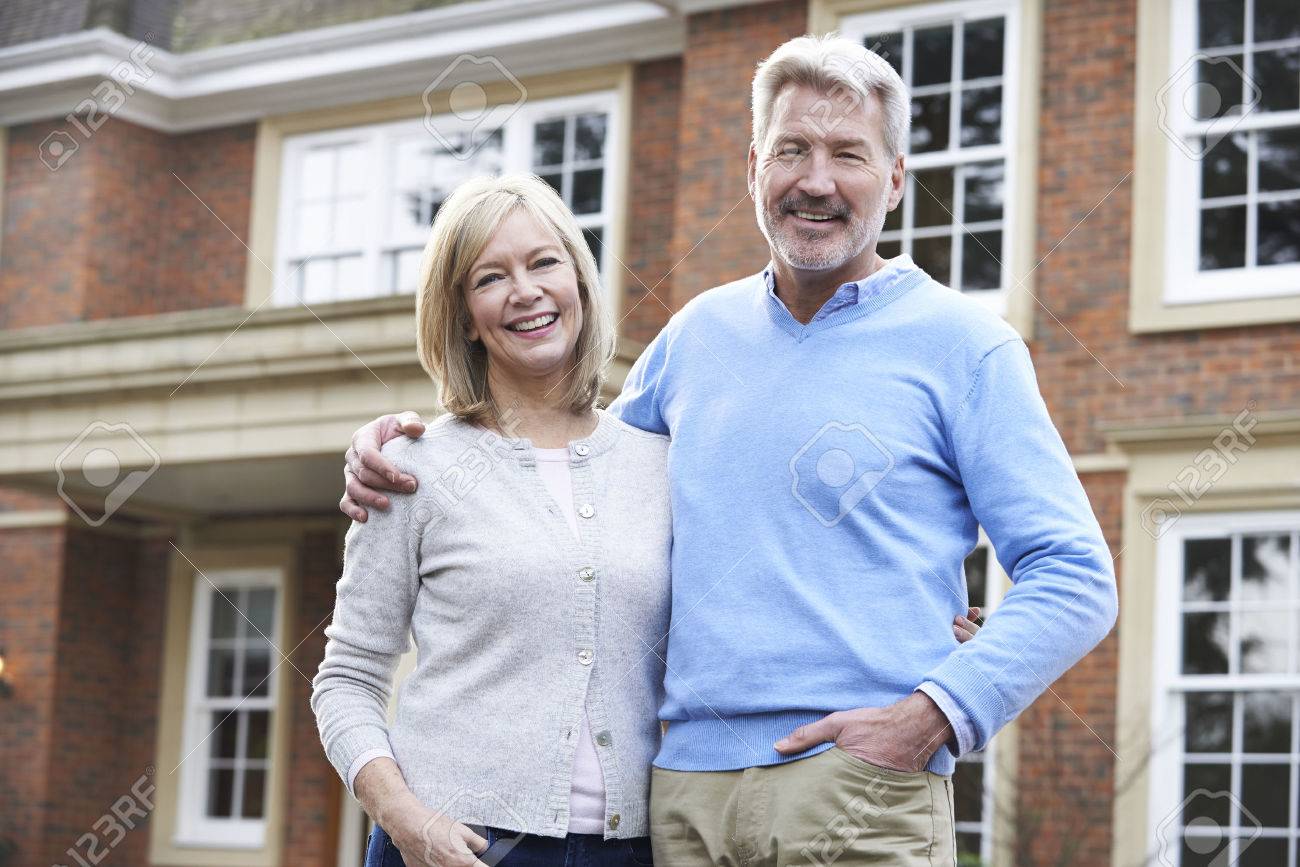 Portrait Of Mature Couple Standing Outside Home - 54904748 Portrait Of Mature Couple Standing Outside Home - 54904748