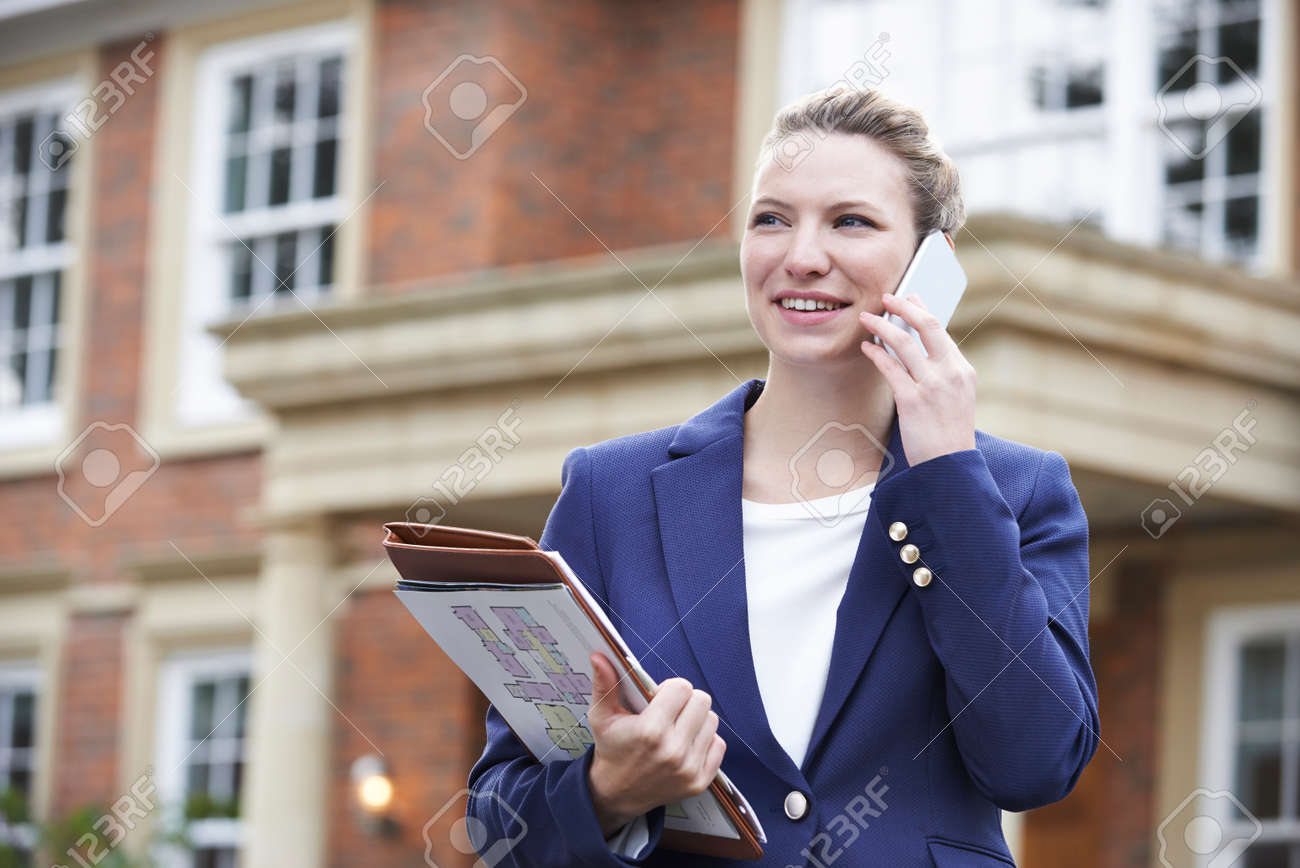 Female Realtor On Phone Outside Residential Property - 54904762 Female Realtor On Phone Outside Residential Property - 54904762