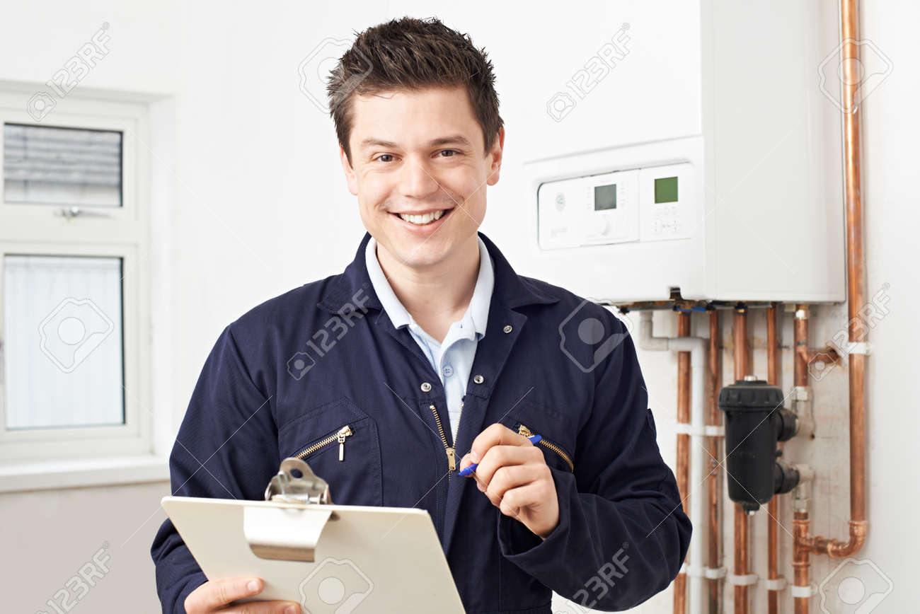 Male Plumber Working On Central Heating Boiler - 56216472 Male Plumber Working On Central Heating Boiler - 56216472