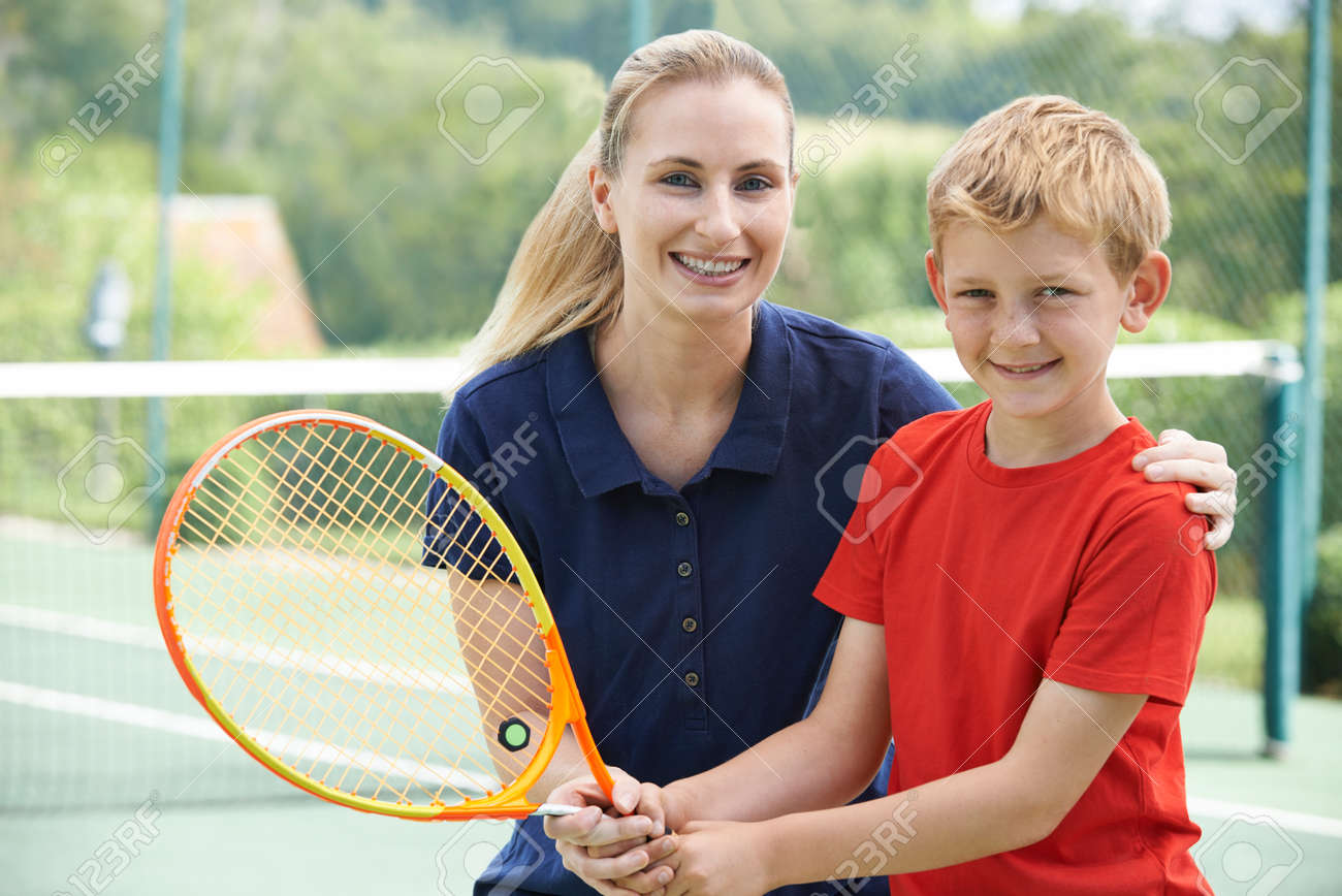 男の子にレッスンを与える女性テニス コーチ の写真素材 画像素材 Image