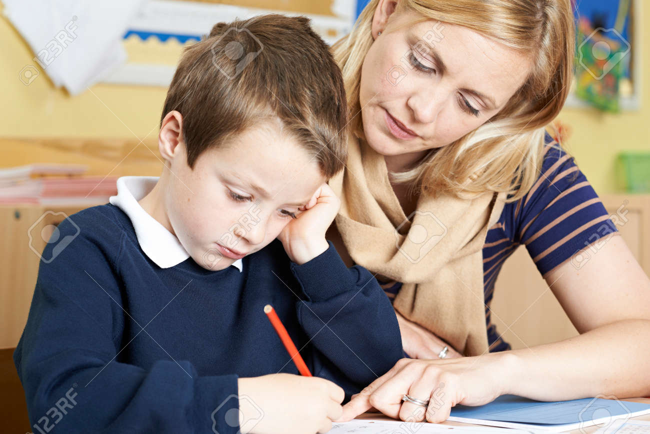 Teacher With Male Elementary School Pupil With Problem - 61521251 Teacher With Male Elementary School Pupil With Problem - 61521251