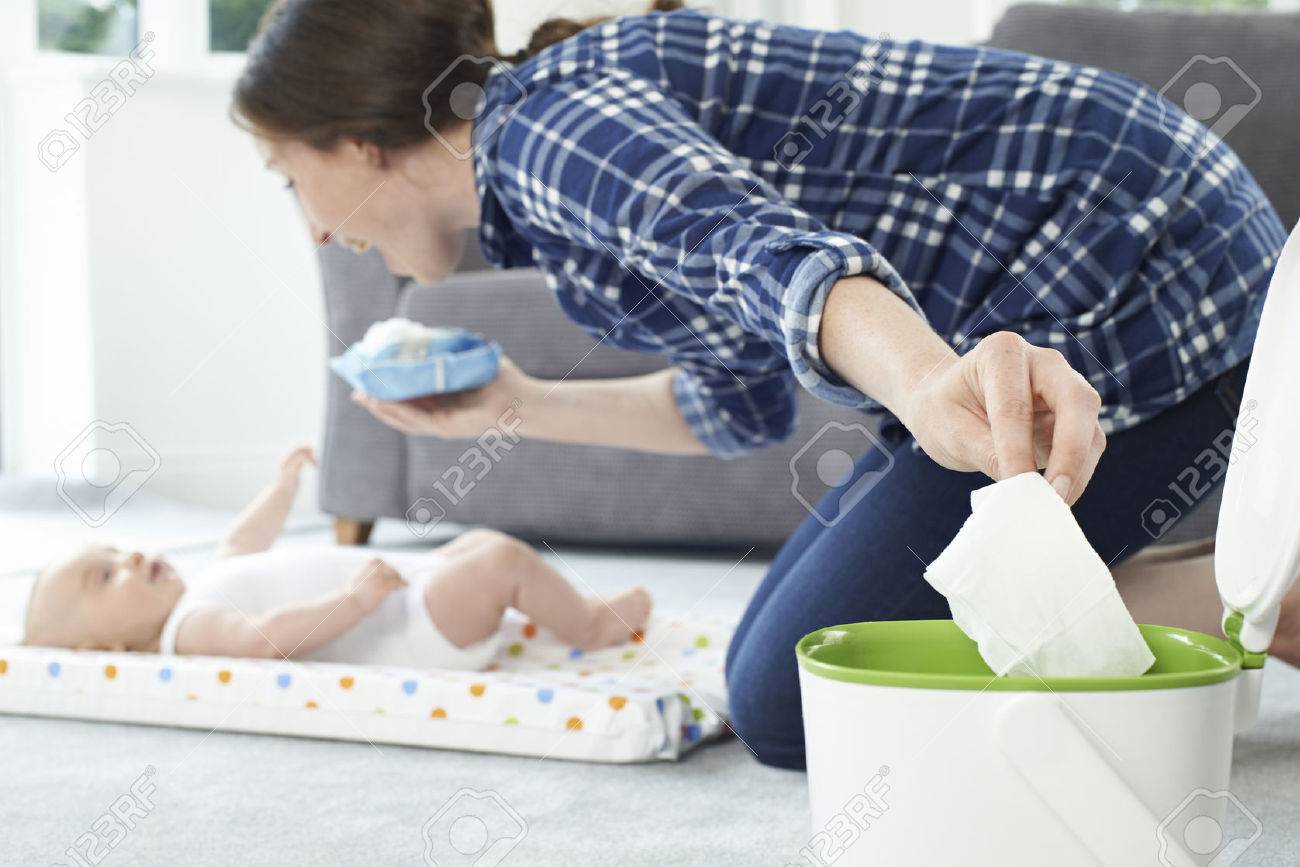Mother Disposing Of Baby Wipe In Bin - 63089858 Mother Disposing Of Baby Wipe In Bin - 63089858