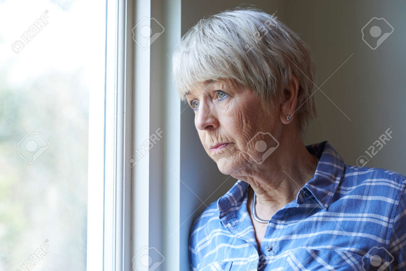 Senior Woman Suffering From Depression Looking Out Of Window - 71624625 Senior Woman Suffering From Depression Looking Out Of Window - 71624625
