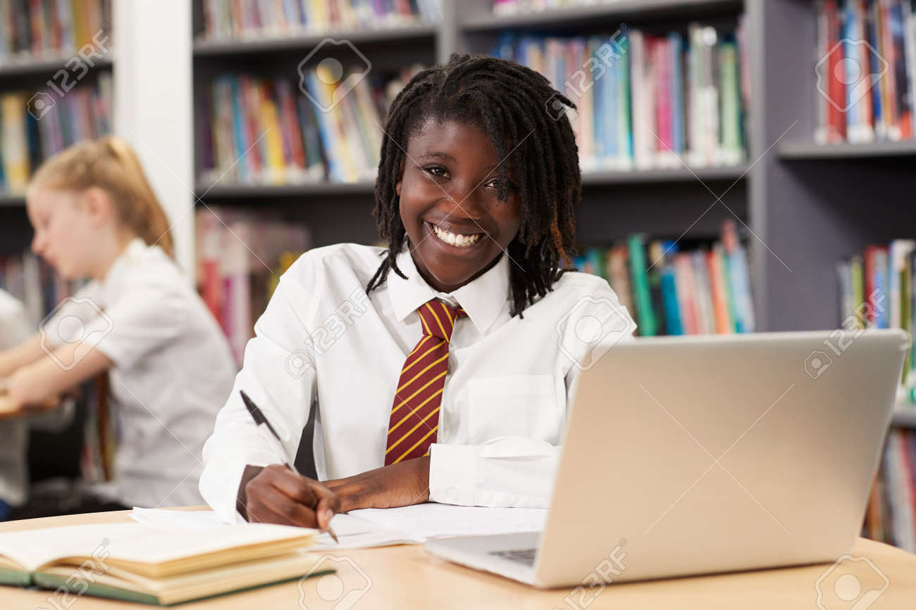 Portrait Of Female High School Student Wearing Uniform Working At Laptop In Library - 108035777 Portrait Of Female High School Student Wearing Uniform Working At Laptop In Library - 108035777