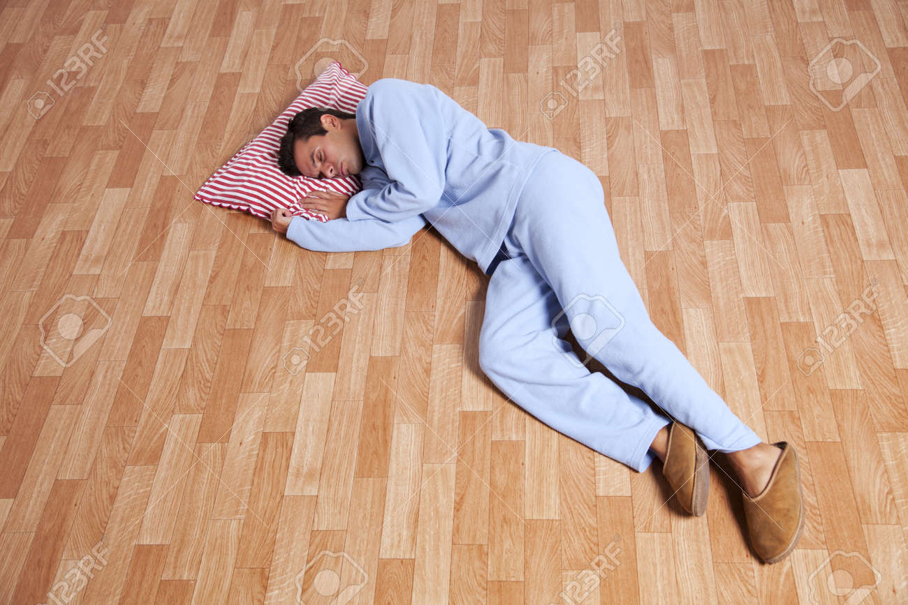 Young Man Dress With Nightclothes Sleeping On The Floor Isolated
