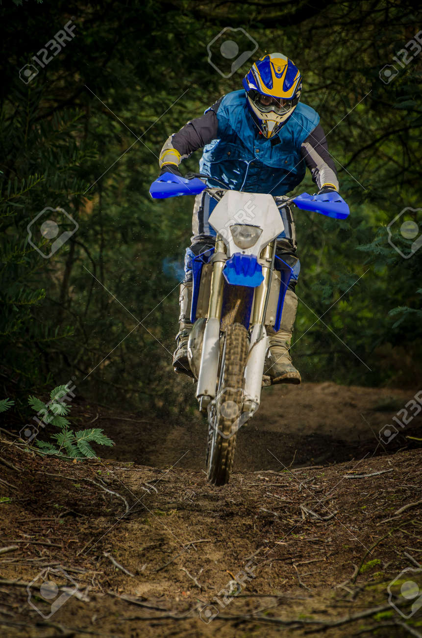 Enduro bike rider on action. Small jamp on muddy terrain. - 17032888 Enduro bike rider on action. Small jamp on muddy terrain. - 17032888