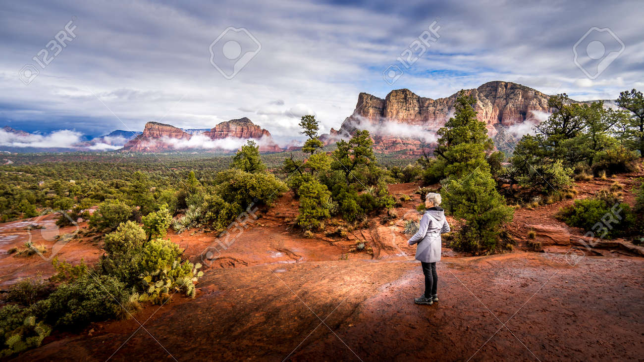 Woman looking at the Red Rocks of Munds Mountain and Surrounding Mountains near the town of Sedona in northern Arizona in Coconino National Forest, USA - 159817625 Woman looking at the Red Rocks of Munds Mountain and Surrounding Mountains near the town of Sedona in northern Arizona in Coconino National Forest, USA - 159817625