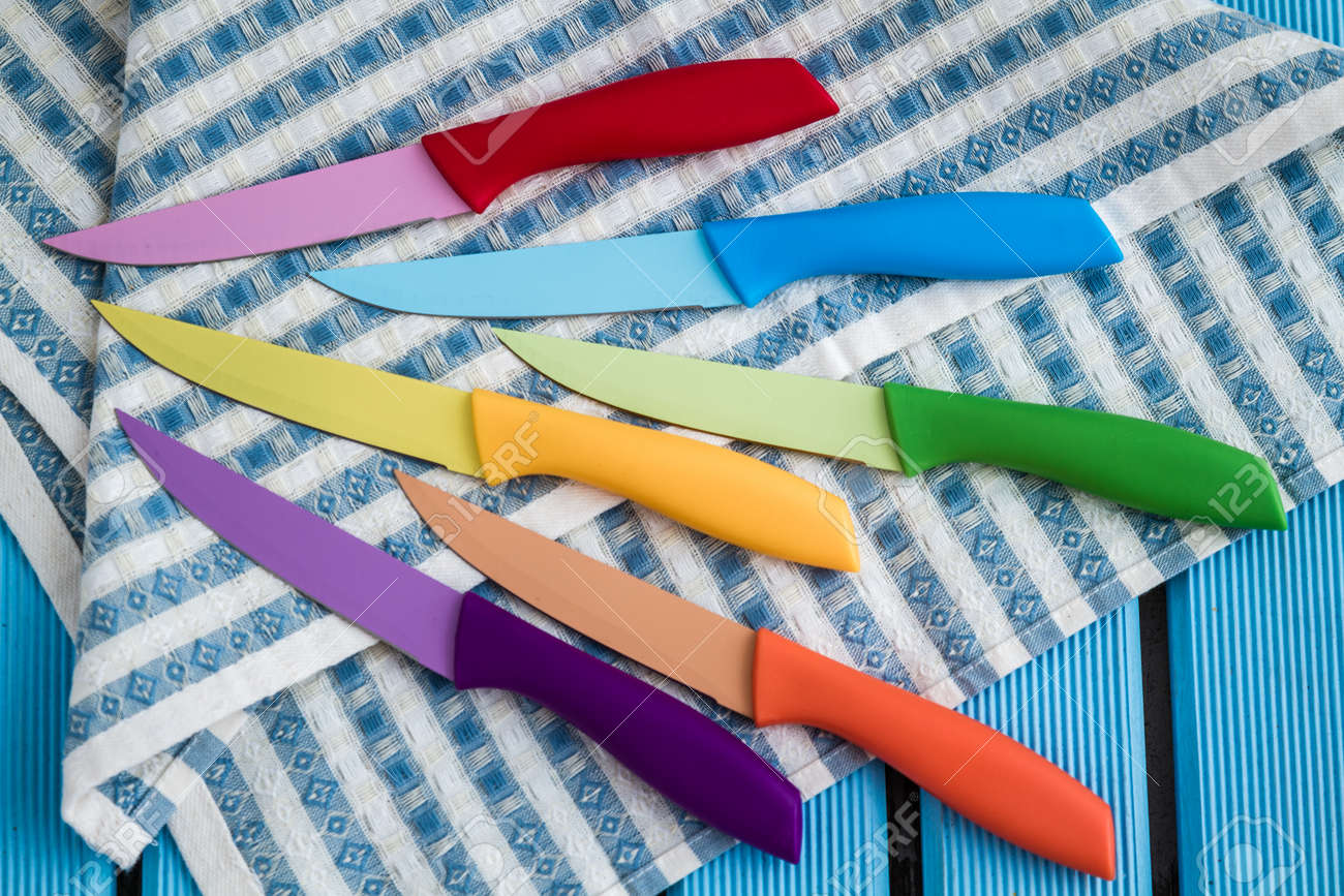 Set Of Colorful Kitchen Knives On Kitchen Napkin Stock Photo