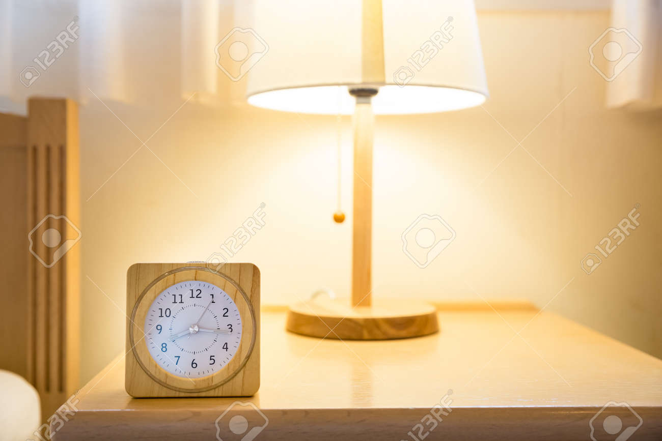 Wooden Clock On Bed Side Table With Lamp Stock Photo Picture And Royalty Free Image Image 123542892