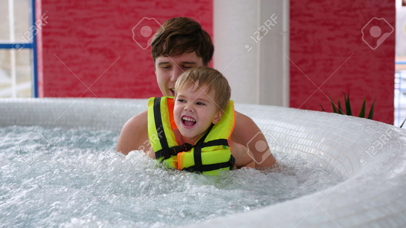 Un Jeune Pere Avec Un Enfant Nage Dans La Piscine Du Spa Detente Un Jeune Pere Avec Un Enfant Nage Dans La Piscine Du Spa Detente