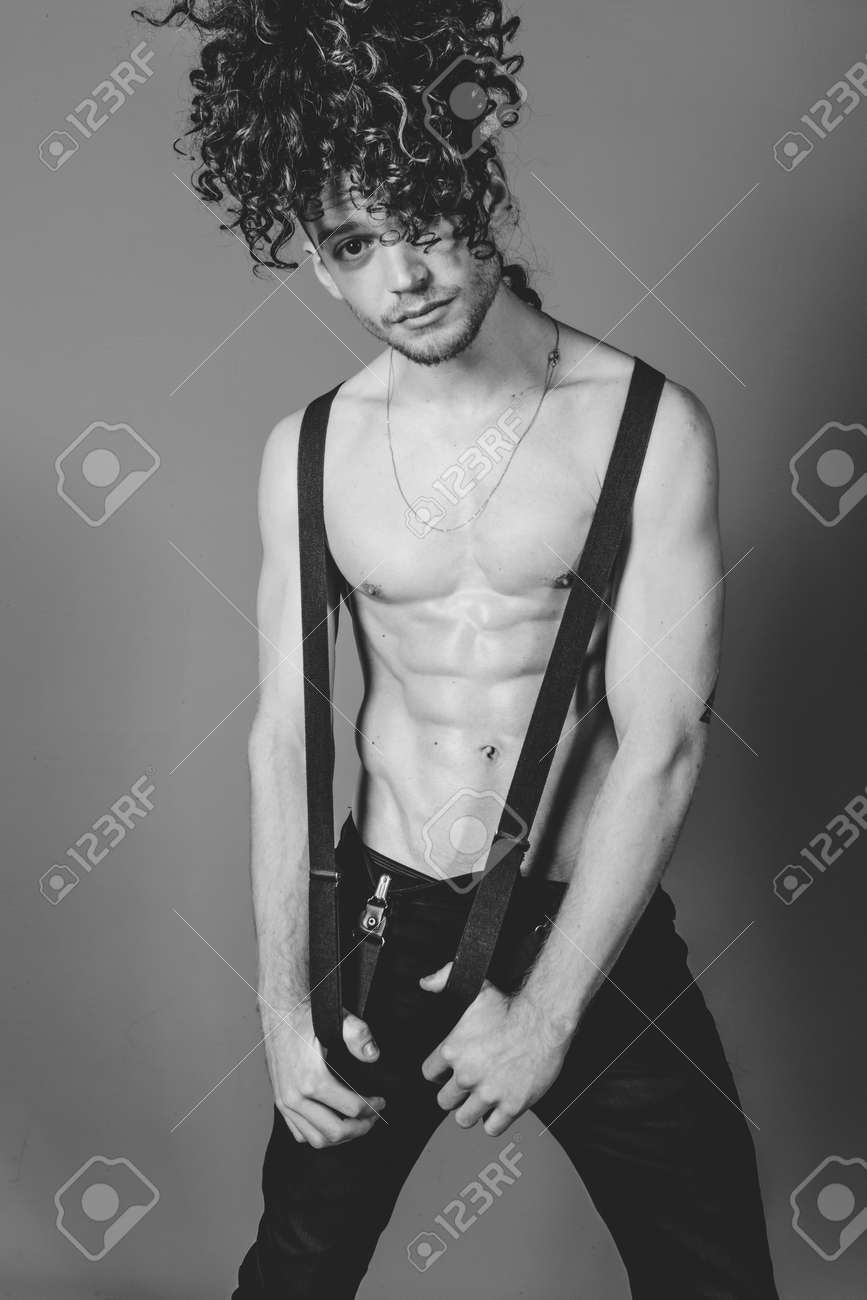 97678389-attractive-young-man-with-long-ginger-curly-hair-and-ripped-muscled-body-wearing-black-jeans-and-bel.jpg