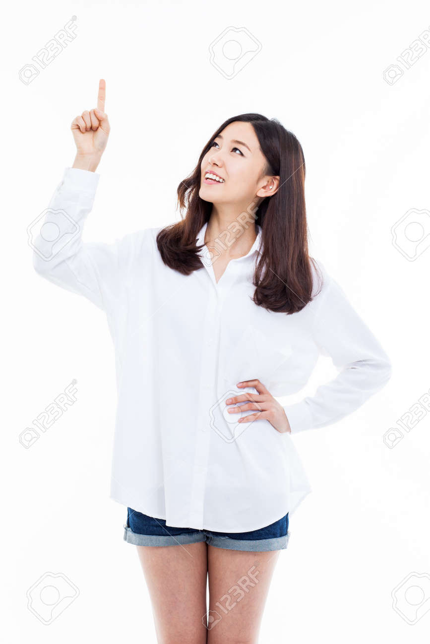 上方に孤立した白い背景を指している若い女性の笑みを浮かべてください の写真素材 画像素材 Image