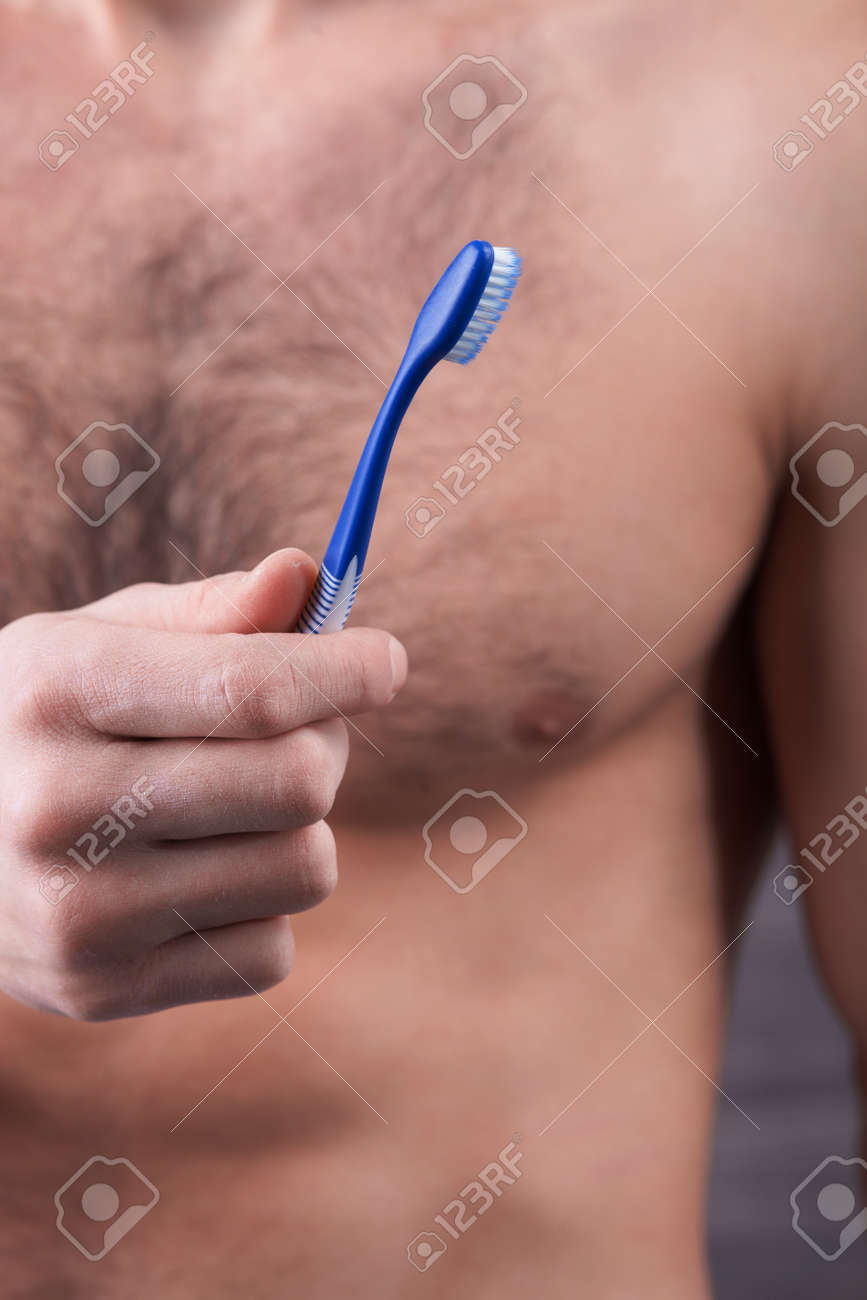 Close Up Of Male Naked Torso. The Man Is Brushing His Teeth. He Is Holding  A Tooth-brush Stock Photo, Picture and Royalty Free Image. Image 51429672.