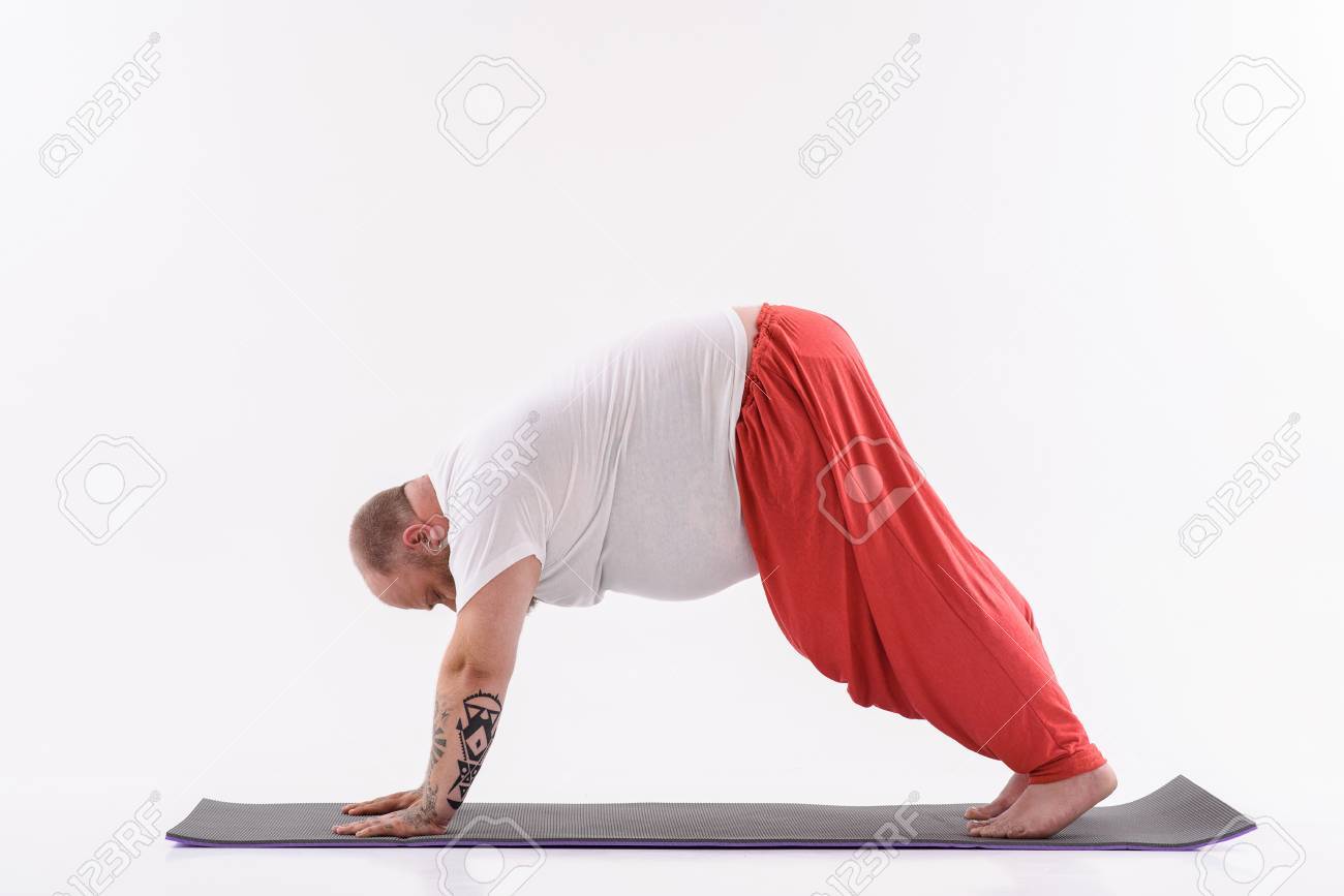 穏やかなデブ男はヨガをやって リラックスします 彼はマットのポーズです 分離されました の写真素材 画像素材 Image
