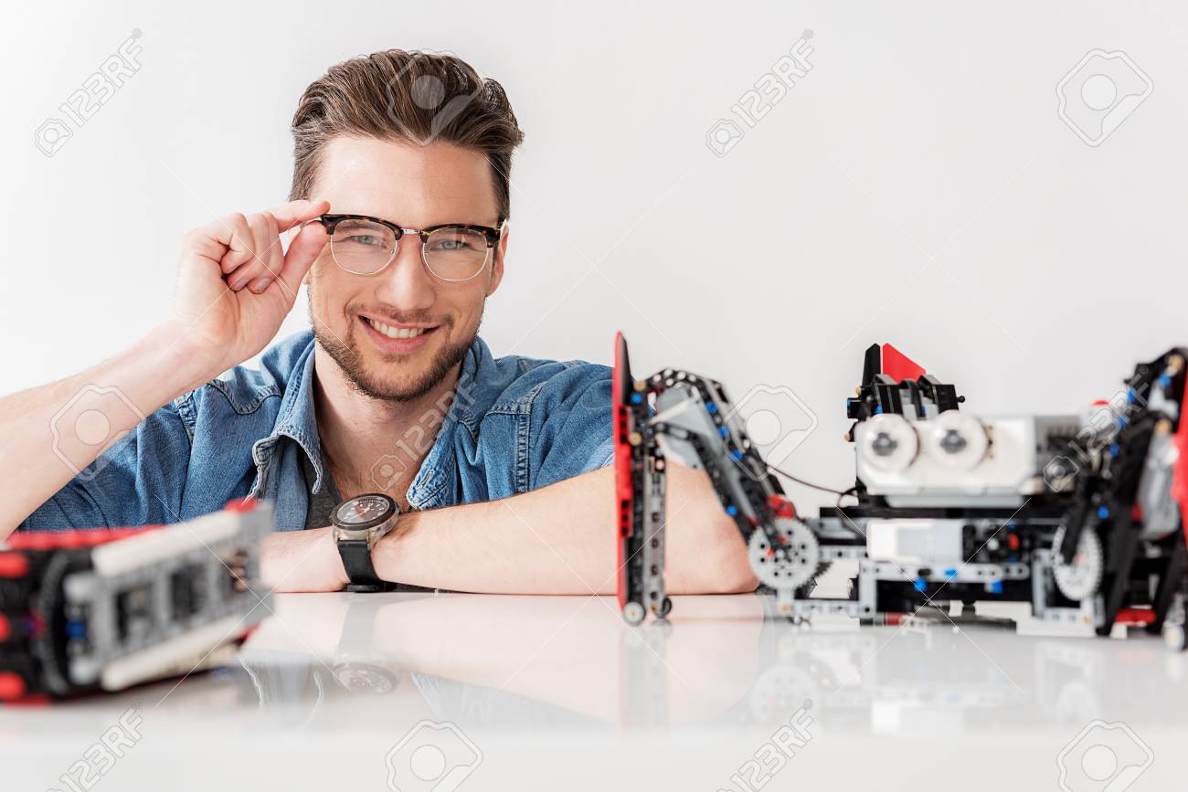 happy smiling male technician squatting behind desk stock photo