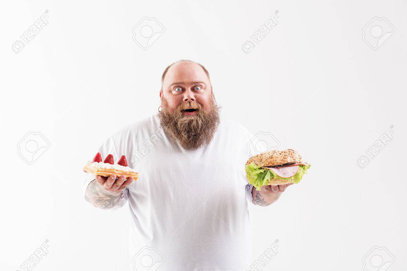 I Cannot Believe In My Happiness Joyful Fat Man Is Holding Large Burger And Cake He Is Standing And Laughing Isolated Stock Photo Picture And Royalty Free Image Image