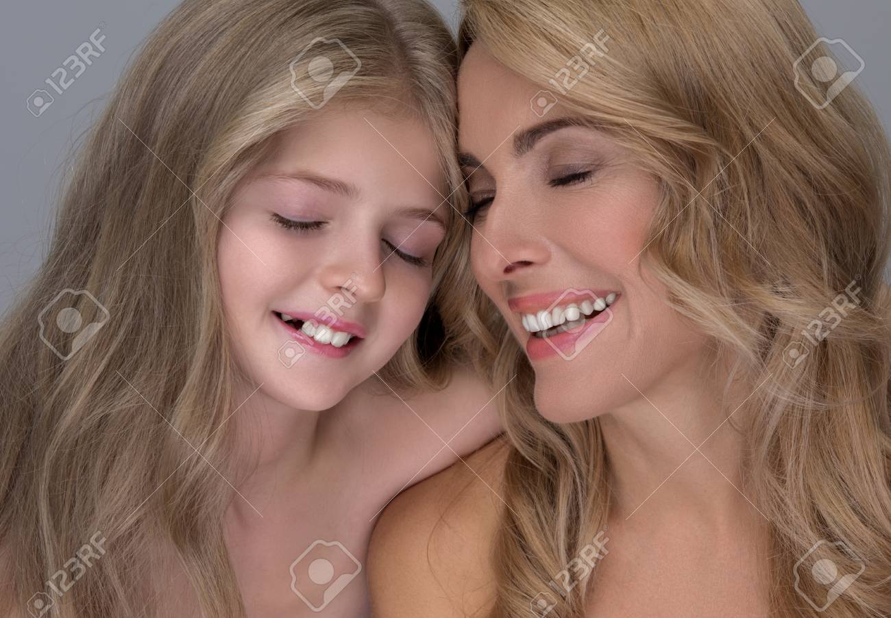 Full large healthy happy family. мама шьет. мама и дочь сидят. Mother and adorable little daughter are standing with naked shoulders while looking at camera with joy. (like) flowers?.