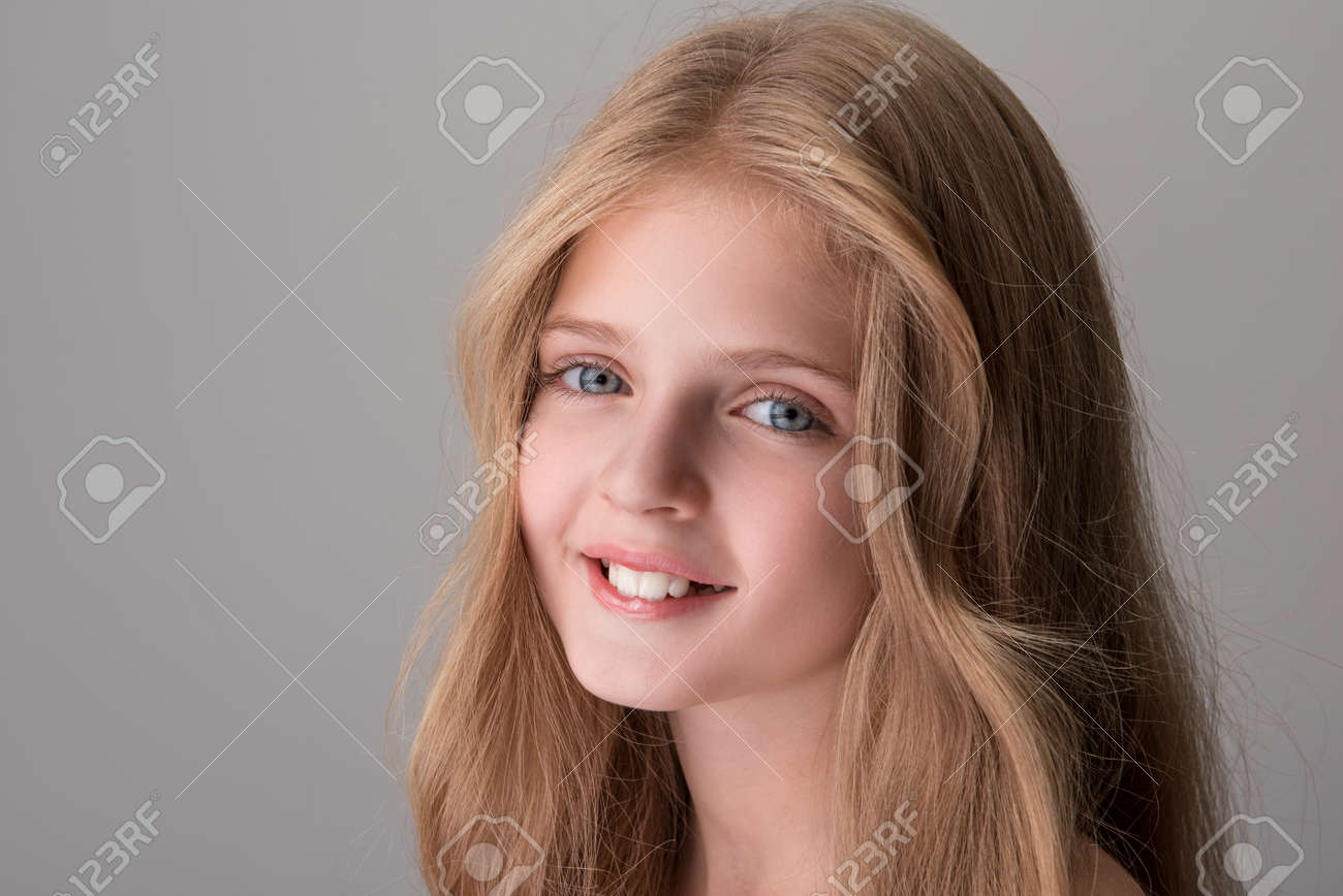 写真　少女 喜びを感じる。ポジティブ可愛い少女のクローズアップポートレートが立って、楽しい笑顔でカメラを見ています。分離された背景の写真素材・画像素材 Image  91545392
