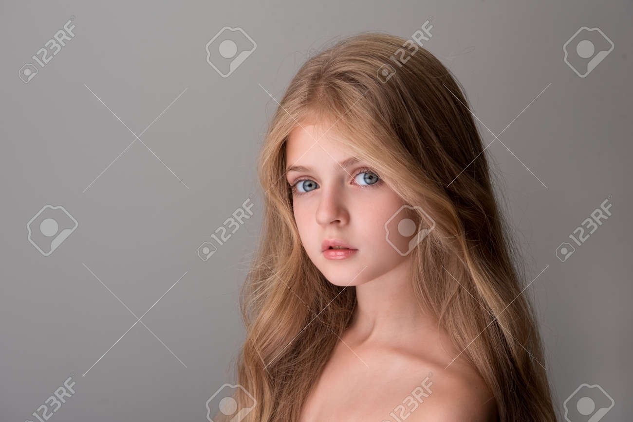 裸の肩と長い髪を持つかわいいかわいい女の子が目に優しさを持つカメラを見ています 左側にコピースペースを持つ分離された背景 の写真素材 画像素材 Image