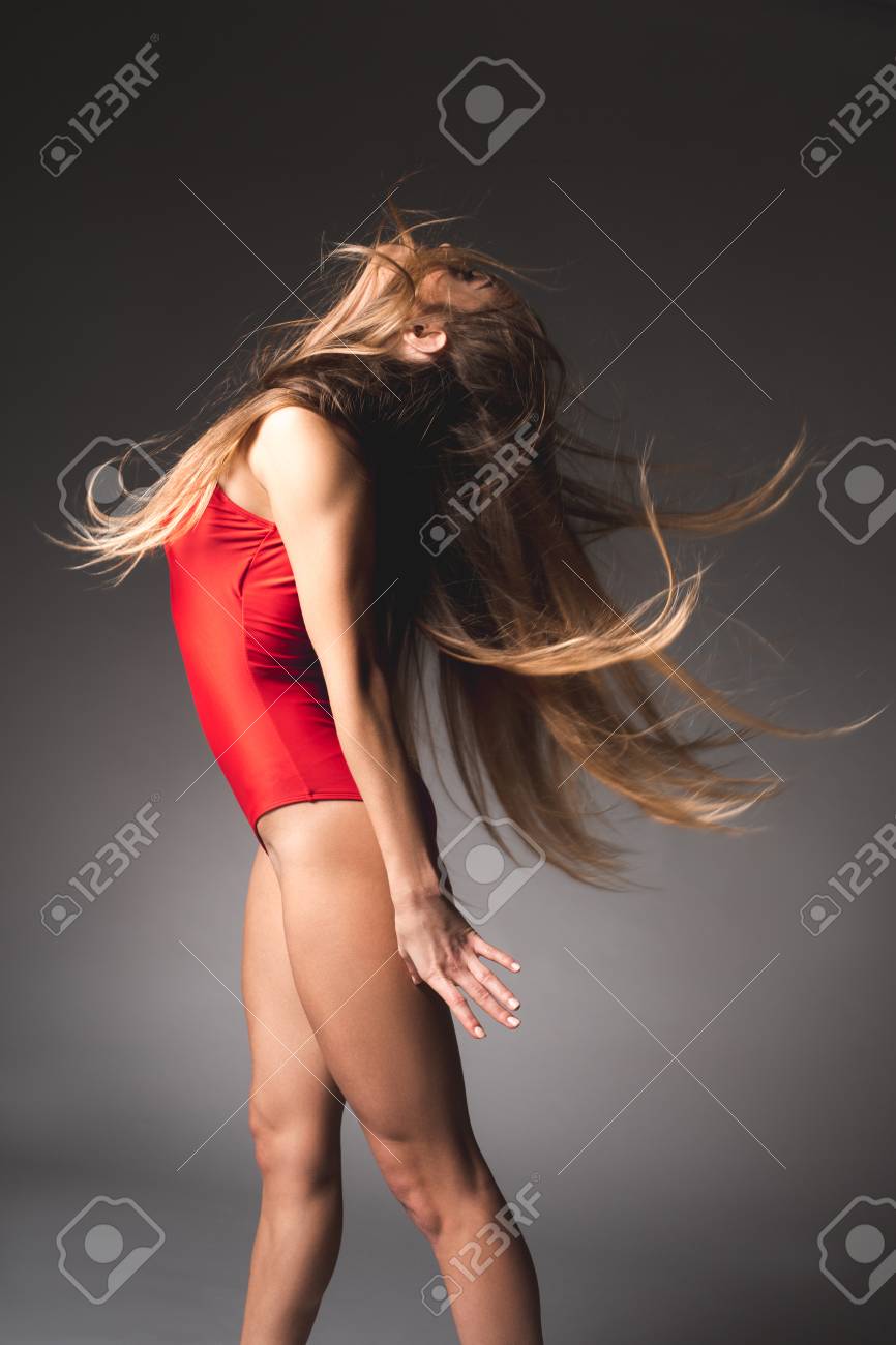 頭を後ろに投げるゆるい髪のエレガントな女の子の側面図 彼女は赤いマイロットを着ています の写真素材 画像素材 Image