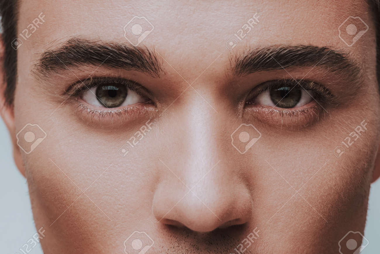 Young Caucasian Man With Green Eyes And Black Eyebrows Looking