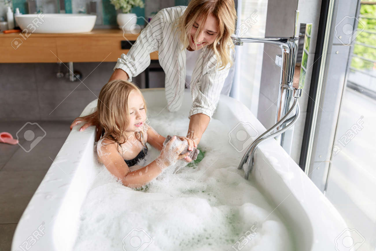 Smiling Mom Feeding Shower Sponge To Daughter Stock Photo, Picture and  Royalty Free Image. Image 129550336.