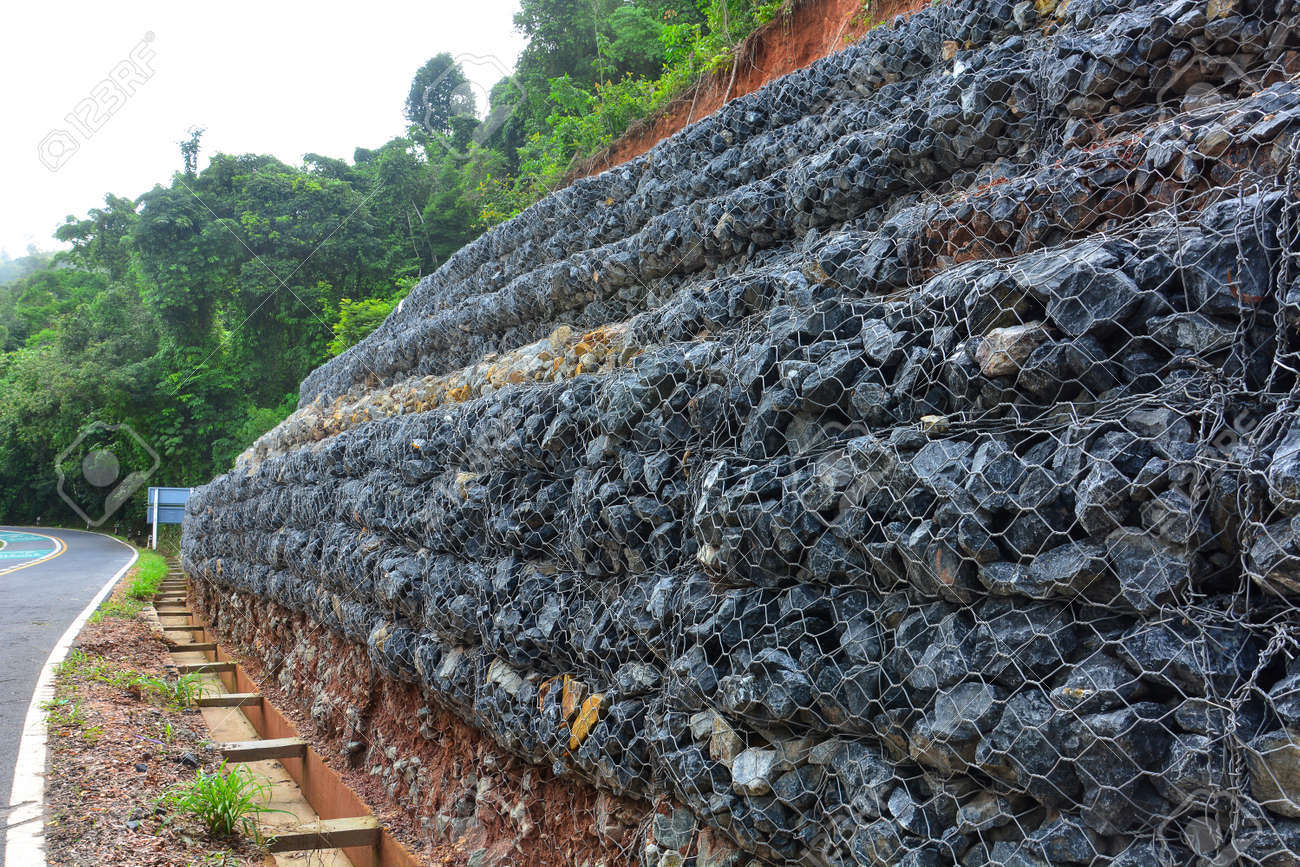 foto de archivo muro de gaviones de piedras en la malla de acero que se utiliza como una valla en una pendiente para el de tierra de - Muro De Gaviones foto de archivo muro de gaviones de piedras en la malla de acero que se utiliza como una valla en una pendiente para el de tierra de - Muro De Gaviones