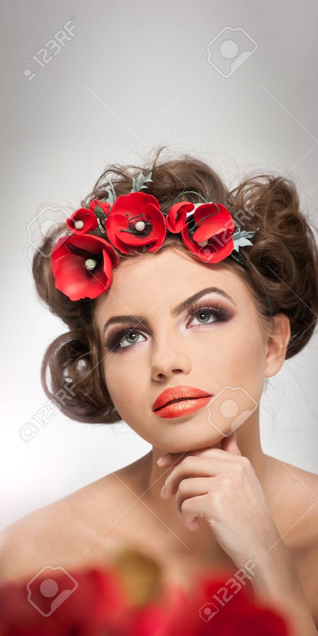 Portrait De Belle Fille En Studio Avec Des Fleurs Rouges Dans Les Cheveux Et Les épaules Nues Sexy Jeune Femme Avec Le Maquillage Professionnel Et