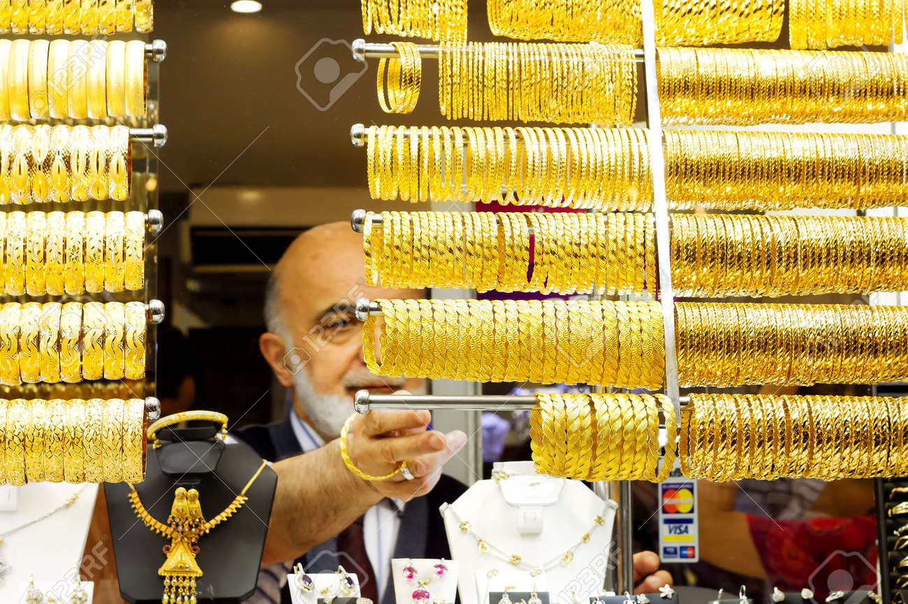 ISTANBUL - JUNE 9: Old sales man lines up bracelets on display at Grand Bazaar on June 9, 2011 in Istanbul. Turkish gold jewellery is a unique heritage which has been passed on from Romans and Ottomans - 9774393 ISTANBUL - JUNE 9: Old sales man lines up bracelets on display at Grand Bazaar on June 9, 2011 in Istanbul. Turkish gold jewellery is a unique heritage which has been passed on from Romans and Ottomans - 9774393