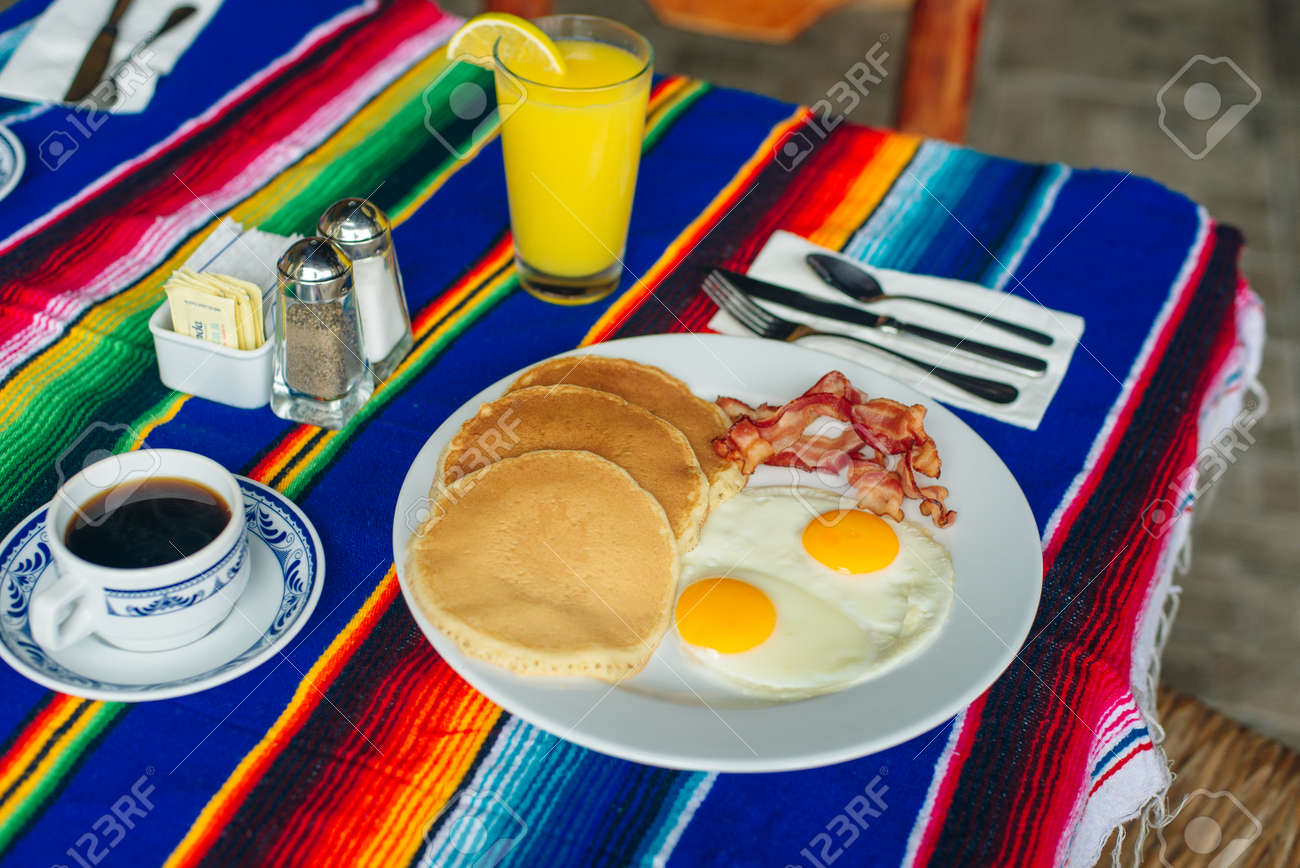 Tasty breakfast with pancakes, fried eggs and bacon on table. - 169530133 Tasty breakfast with pancakes, fried eggs and bacon on table. - 169530133