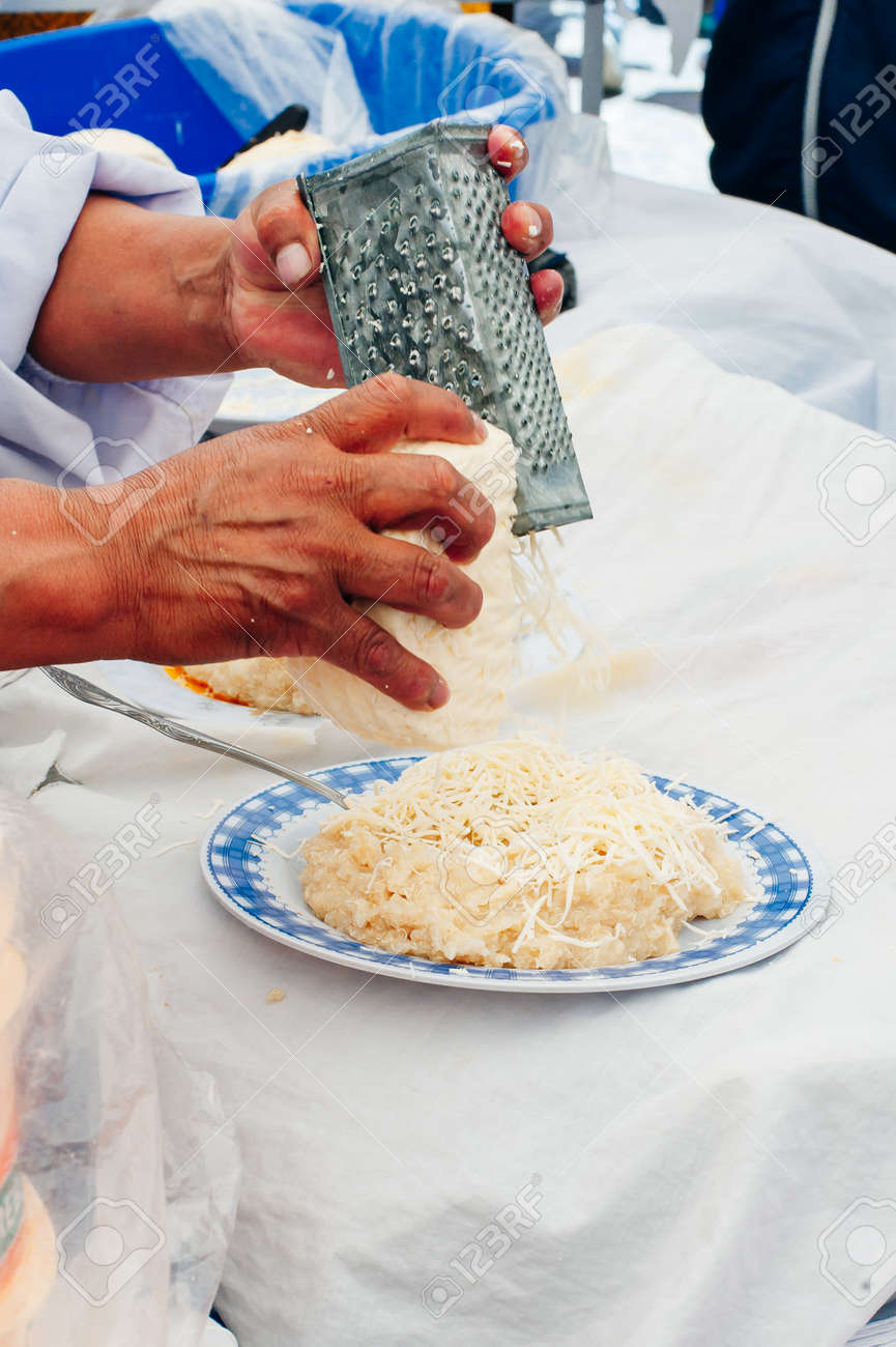 Woman preparing cheese for cook using cheese grater in the kitchen. - 169532679 Woman preparing cheese for cook using cheese grater in the kitchen. - 169532679