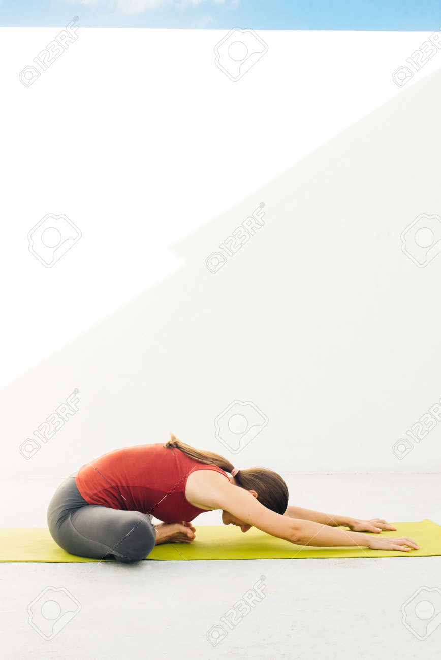 Side view portrait of beautiful young woman doing yoga or pilates exercise. - 169579917 Side view portrait of beautiful young woman doing yoga or pilates exercise. - 169579917