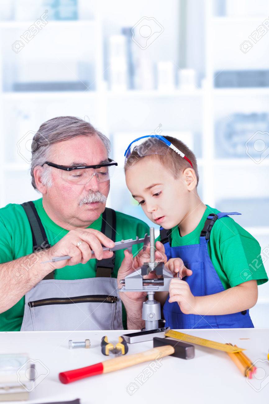 Grandfather teaching grandchild measuring with vernier caliper - 23880330 Grandfather teaching grandchild measuring with vernier caliper - 23880330