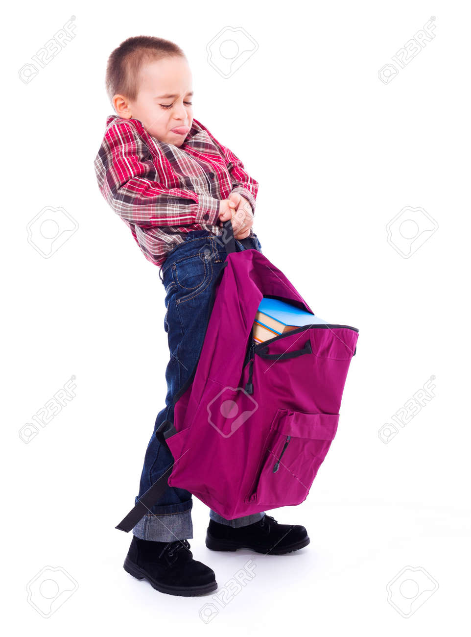 Little boy lifting big, heavy schoolbag full of books - 23955979 Little boy lifting big, heavy schoolbag full of books - 23955979