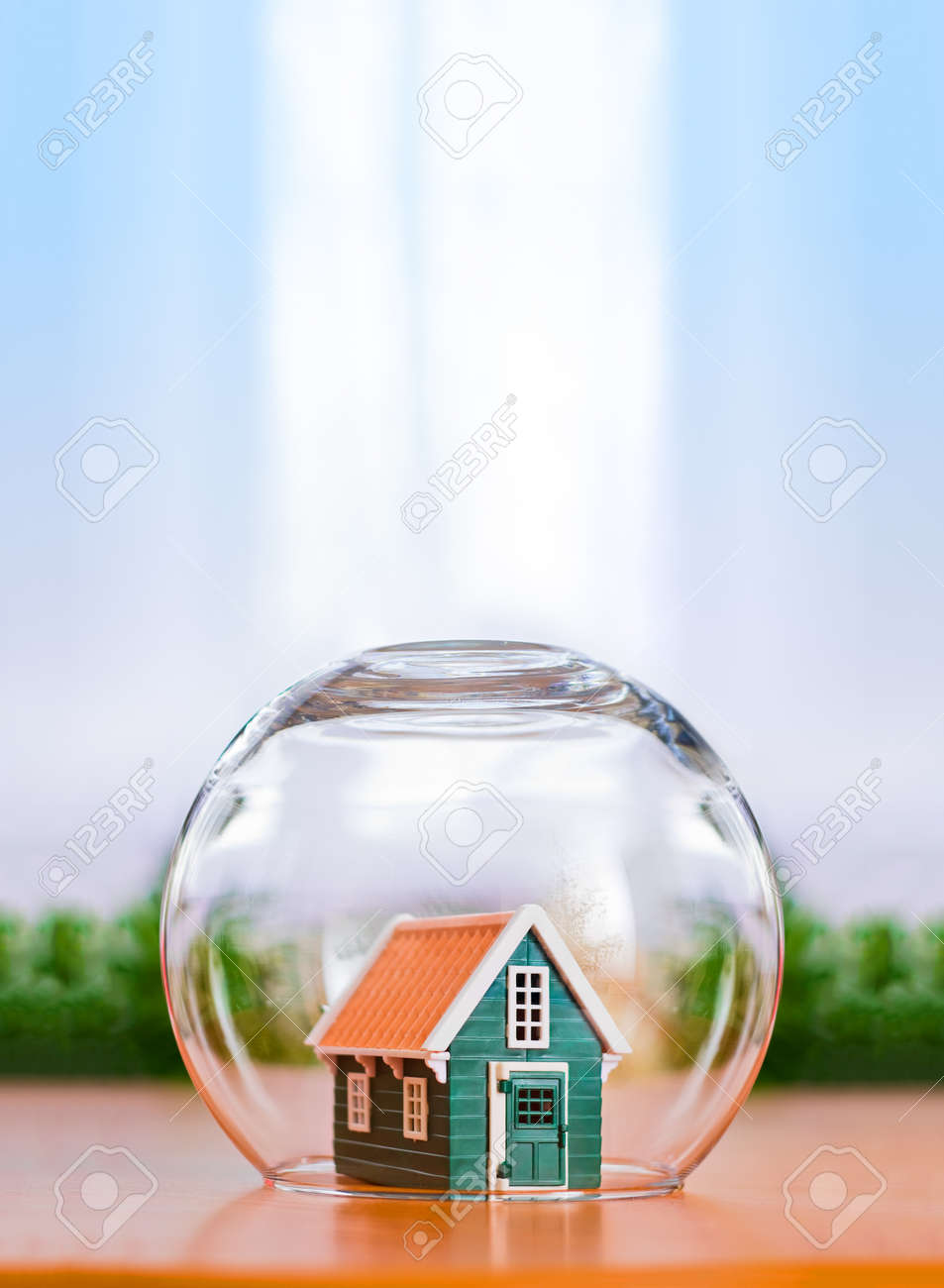Insured house concept. Toy house protected in glass sphere with copy space above - 35244009 Insured house concept. Toy house protected in glass sphere with copy space above - 35244009