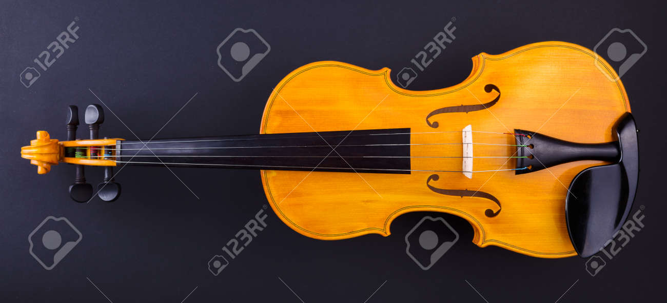 Front View Of A Yellow Violin On Black Stock Photo Picture And