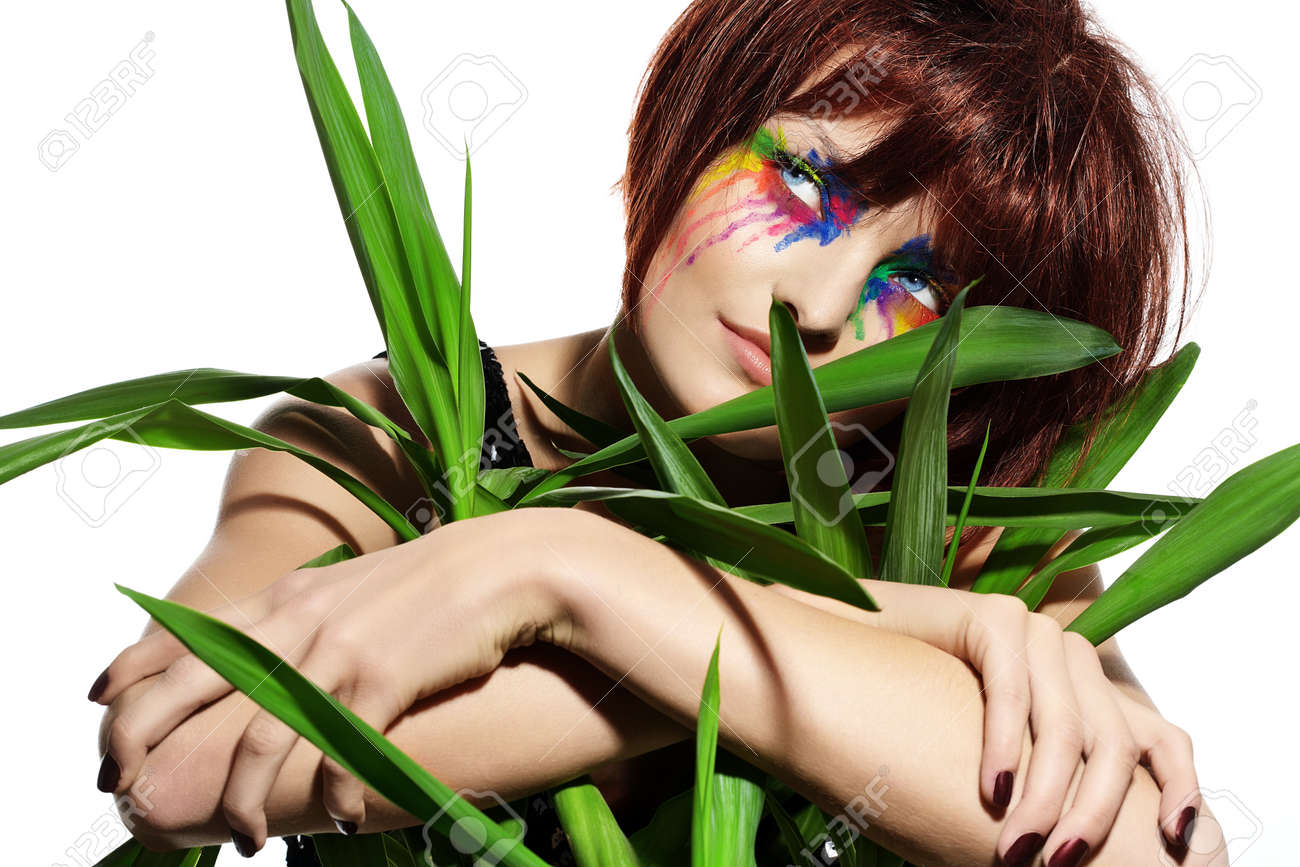 短い褐色のふわふわの髪と緑の植物でポーズ カラフルなメイクとファッション モデル の写真素材 画像素材 Image