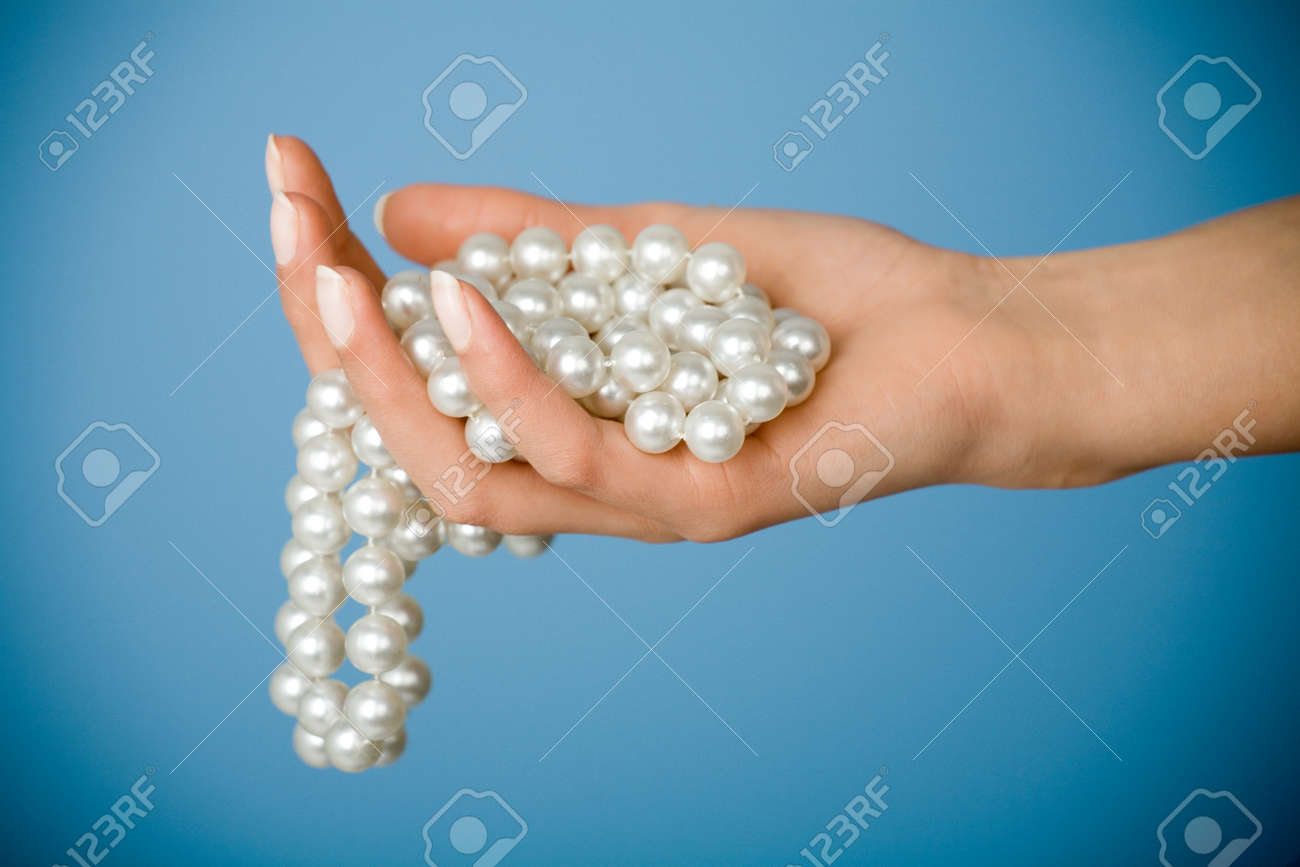 Female hand holding string of fake pearls. - 38509579 Female hand holding string of fake pearls. - 38509579